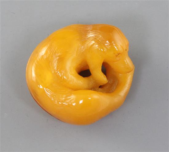 Alfred Lyndhurst Pocock (1882-1962), a carved amber model of a recumbent dog, mid 20th century, 4.1cm